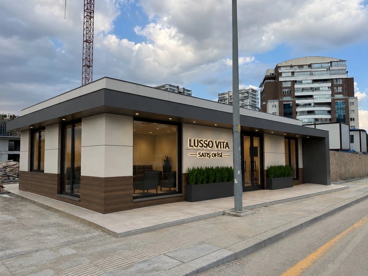 Lusso Vita satış ofisinin beyaz, ahşap görünümlü kaplama ve antrasit saçaklı gerçek dış cephe fotoğrafı